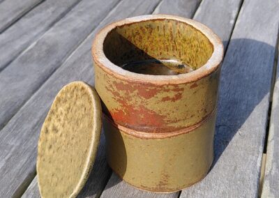 Double boite ronde avec compartiments qui s'empilent. Cuite au bois. Couleur ocre et rouge.